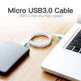 USB 3.0 Micro B cable connecting a portable drive to a laptop for high-speed data transfer