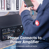 Person using USB-C to Dual RCA cable to connect phone to power amplifier for home audio